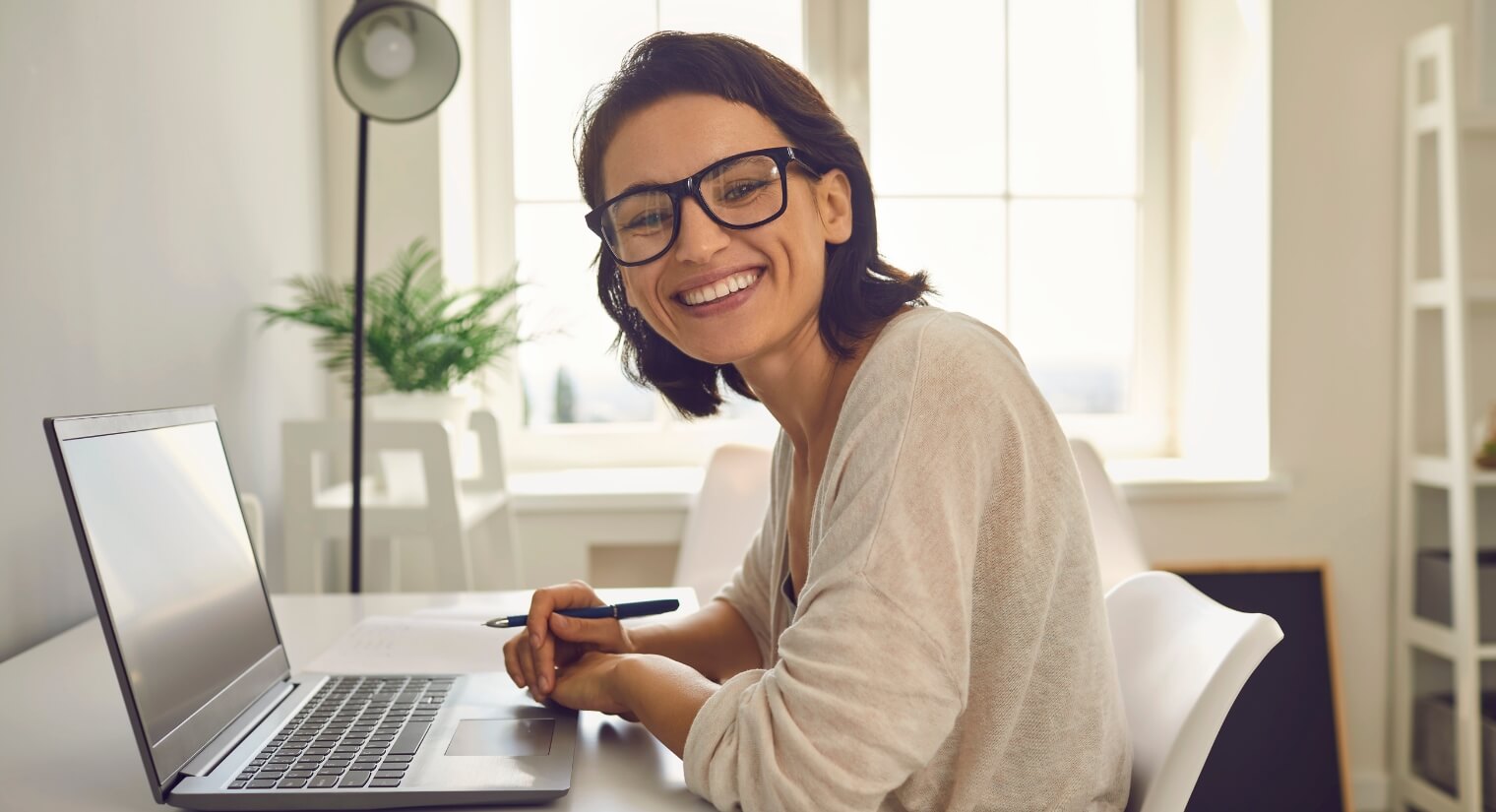 woman smiling whilst working on laptop
